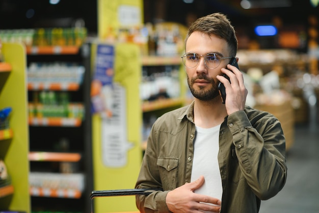 Un bel homme fait ses courses dans un supermarché.