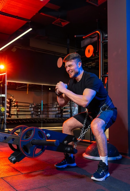 Bel homme fort s'entraînant dans la salle de sport Athlétique faisant des exercices dans une salle de sport moderne