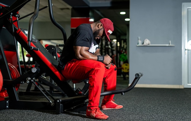 Bel homme fort se reposer après l'entraînement. Homme athlétique musculation dur dans la salle de gym.