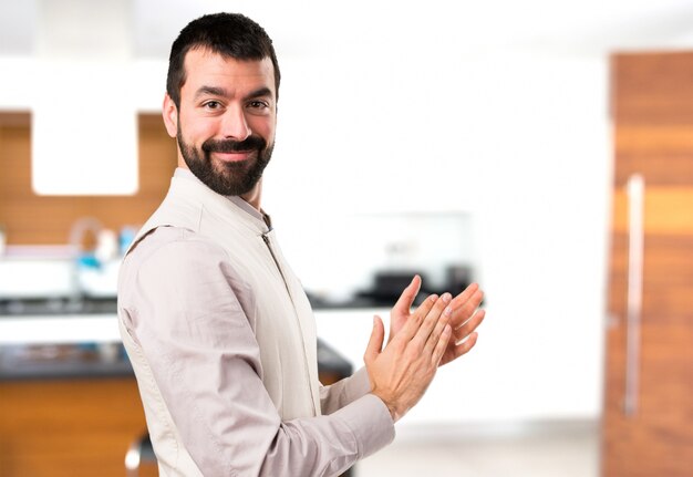 Bel homme avec gilet applaudir à l&#39;intérieur de la maison