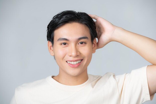 Bel homme heureux souriant confiant toucher les cheveux avec le geste de la main