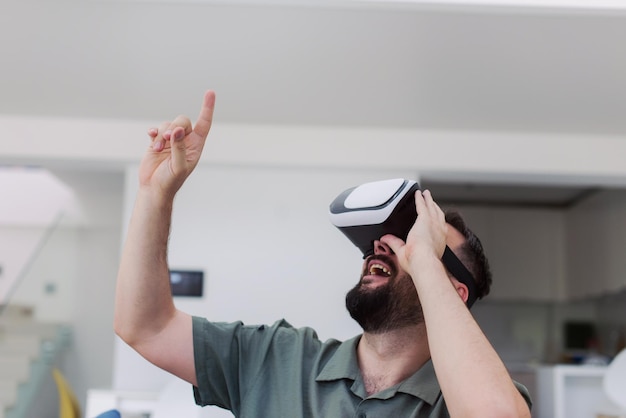 bel homme hipster avec barbe essayant des lunettes vr à la maison moderne