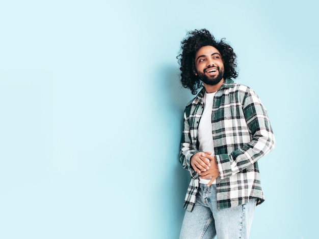 Bel homme hipster souriant qui pose en studio