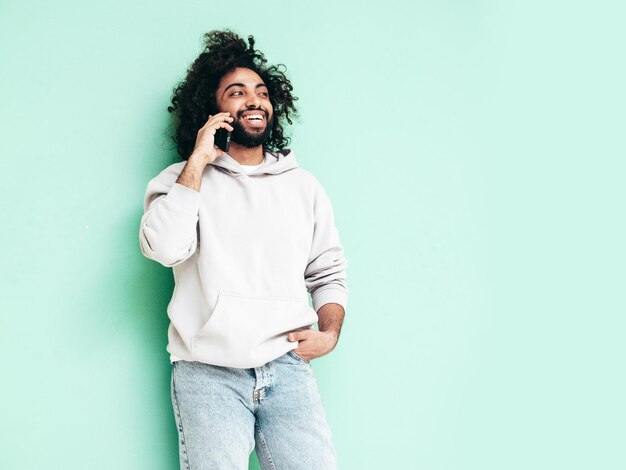 Bel homme hipster souriant qui pose en studio