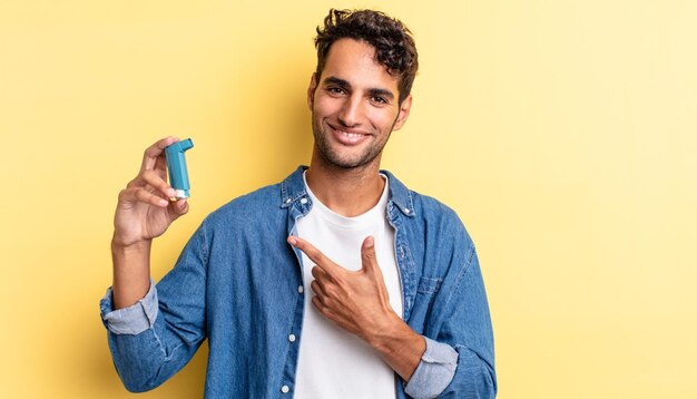 Bel homme hispanique à l'air excité et surpris en pointant sur le côté. concept d'asthme