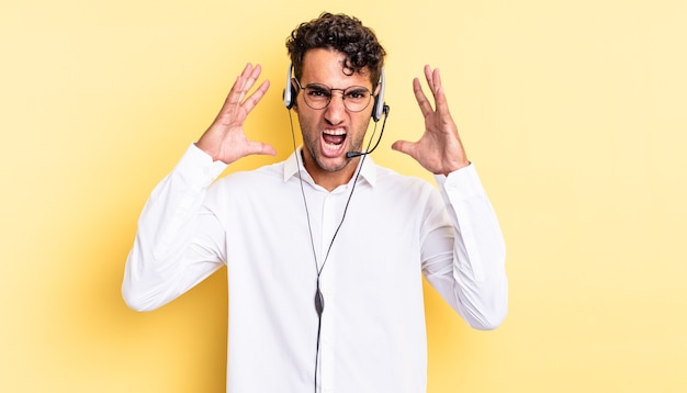 Bel homme hispanique criant avec les mains en l'air. concept de télévendeur