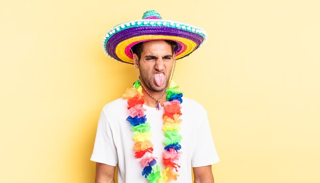 Bel homme hispanique se sentant dégoûté et irrité et tirer la langue. concept de fête mexicaine