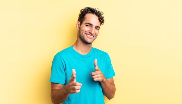 Bel homme hispanique se sentant heureux, cool, satisfait, détendu et réussi, pointant vers la caméra