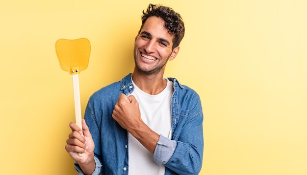 Bel homme hispanique se sentant heureux et faisant face à un défi ou célébrant. tue le concept des mouches