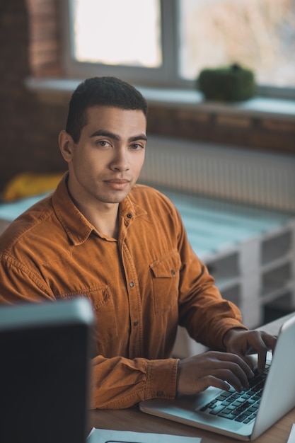 Bel homme intelligent travaillant assis sur son lieu de travail