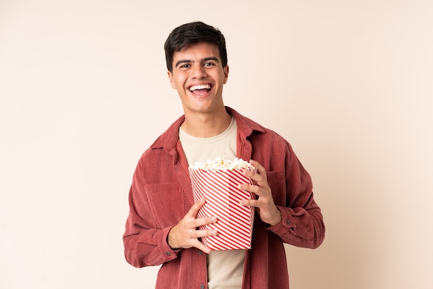 Bel homme sur isolé tenant un gros seau de pop-corn