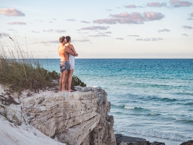 Un bel homme et une jolie femme se tiennent sur fond de rocher