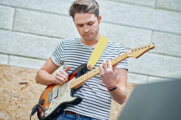 bel homme jouant de la guitare en studio