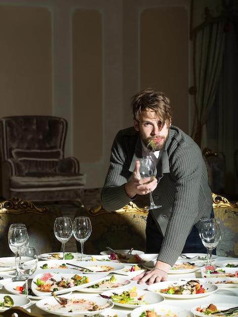 Le bel homme mange après le banquet