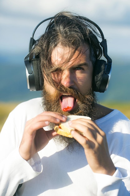 Bel homme mange un sandwich