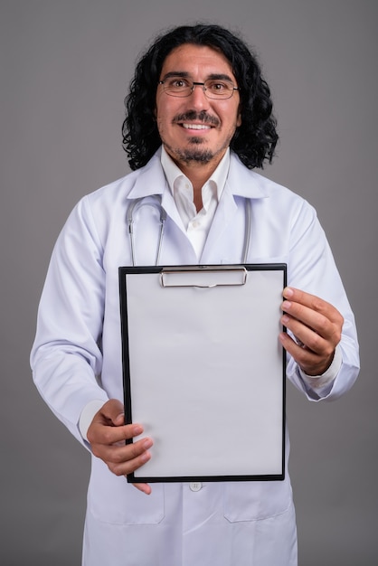 Bel homme médecin avec moustache contre mur gris