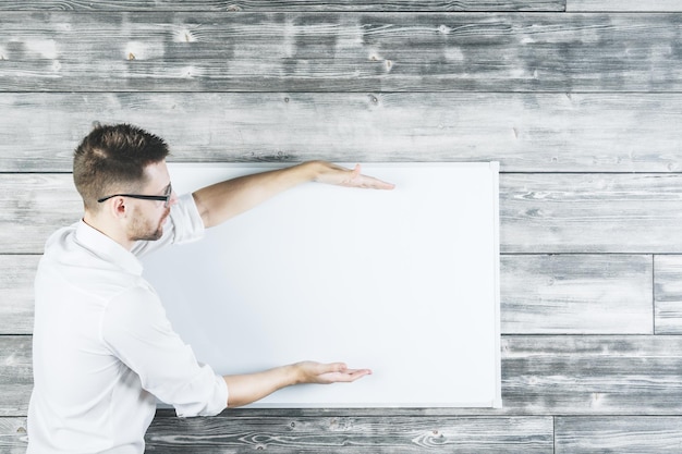 Bel homme montrant la taille sur tableau blanc