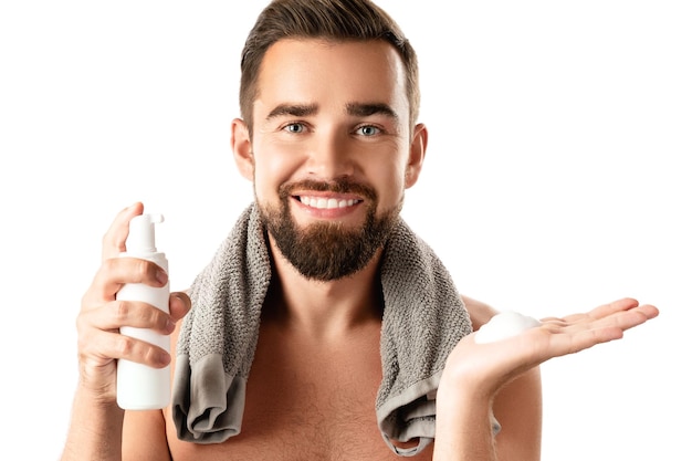 Bel homme avec une mousse nettoyante ou à raser sur fond blanc