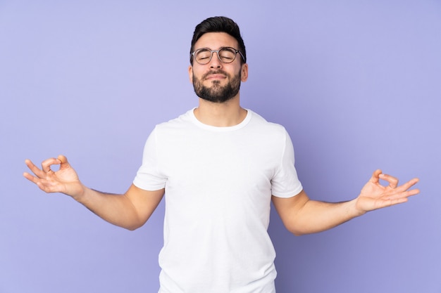 Bel homme sur un mur isolé dans une pose zen