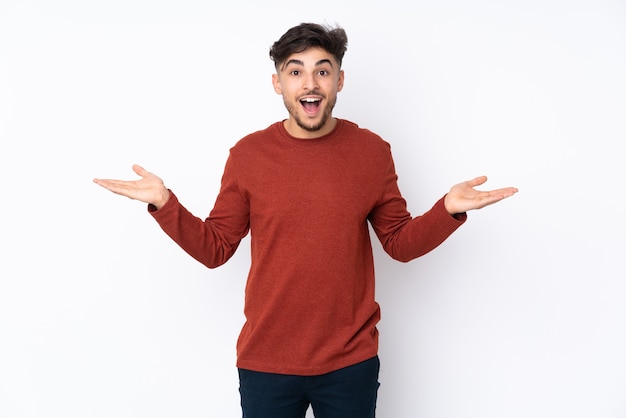 Bel homme sur un mur isolé avec une expression faciale choquée