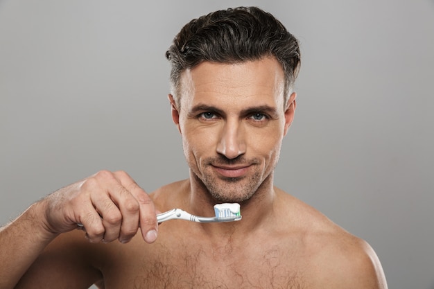 Bel homme mûr se brosser les dents.