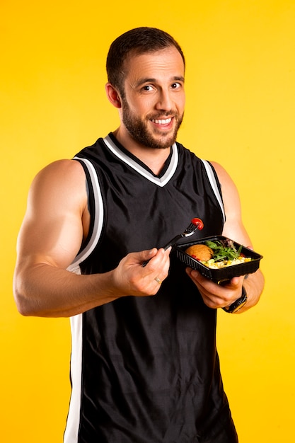 Bel homme musclé avec des boîtes de nourriture