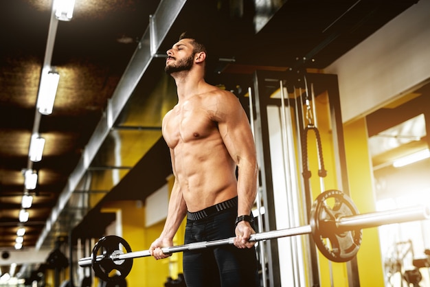 Bel homme musclé travaillant au gymnase.