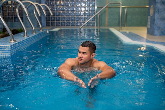 Bel homme nageant dans la piscine