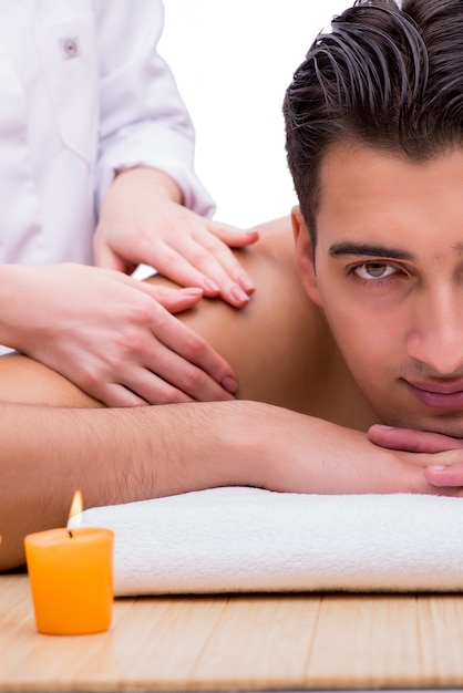Photo bel homme pendant la séance de massage spa