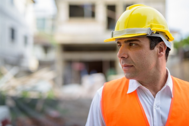 Bel homme persan travailleur de la construction au siège de la construction