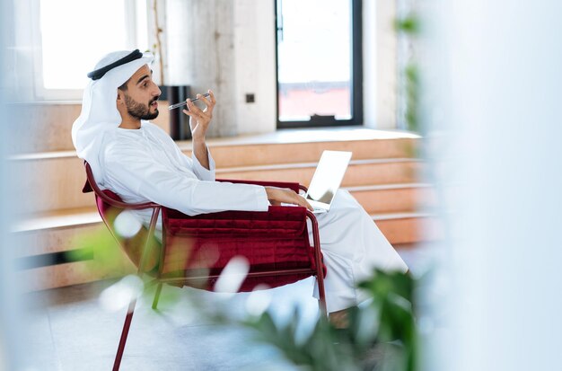 Bel homme avec plat dasha travaillant dans son bureau d'affaires de Dubaï