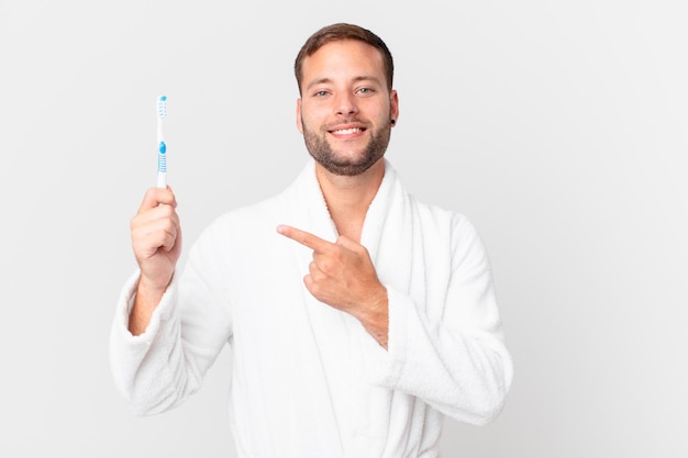 bel homme portant un peignoir et tenant une brosse à dents