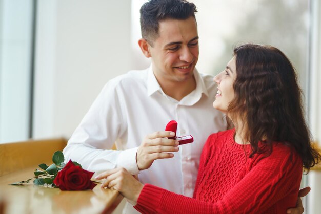 Bel homme proposant à une belle femme de l'épouser au restaurant Concept de la Saint-Valentin