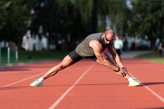 Bel homme qui s'étire avant de faire de l'exercice à l'extérieur