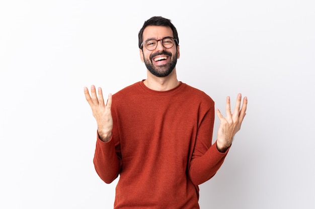 Bel homme de race blanche avec barbe sur mur blanc isolé souriant beaucoup