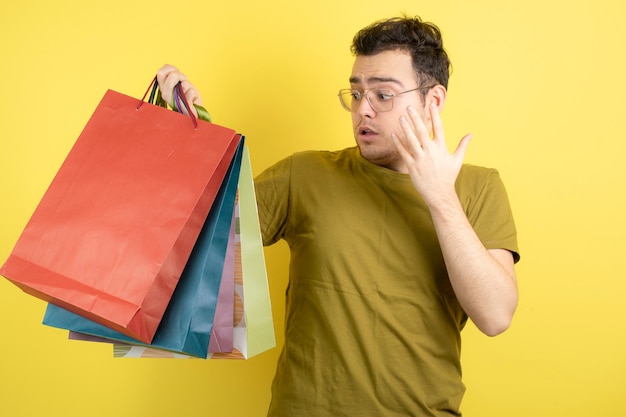 bel homme regardant des sacs colorés.