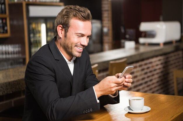 Bel homme regardant smartphone et prendre un café