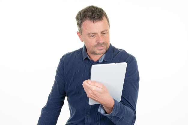 bel homme regarde et lit sa tablette tactile numérique