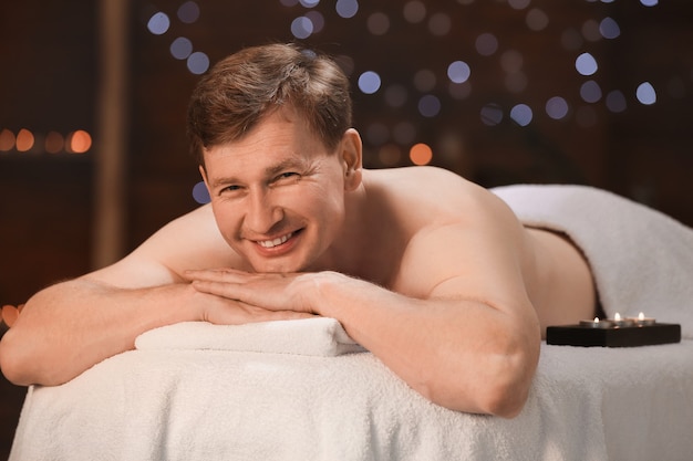 Bel homme relaxant dans un salon spa