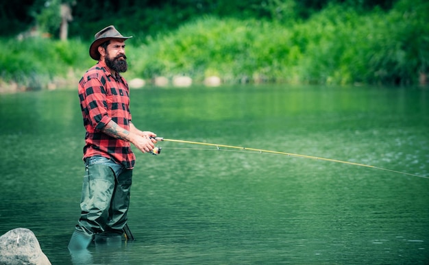 Bel homme relaxant les week-ends d'été ou les vacances unis à la nature pêche au bord du lac semaine d'été