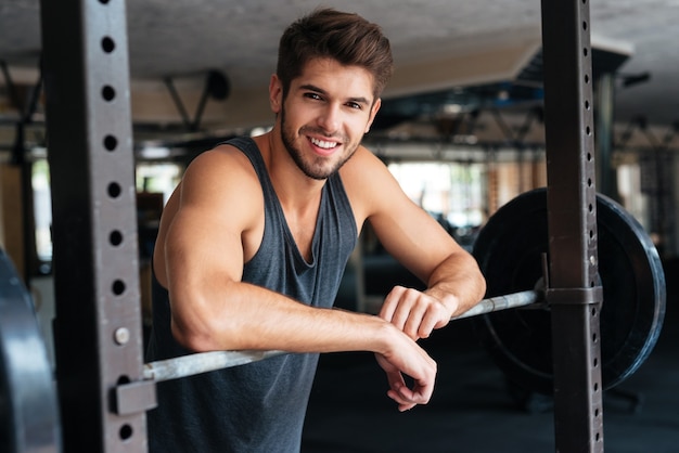 Bel homme de remise en forme avec des poids. Souriant.