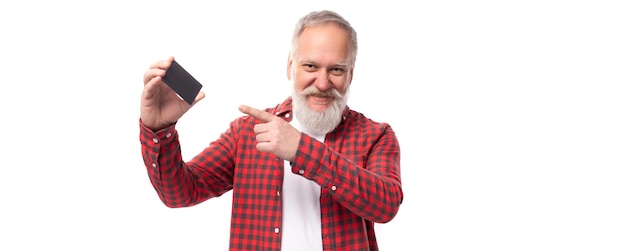 Un bel homme à la retraite avec une barbe blanche et une moustache montrant une carte bancaire.