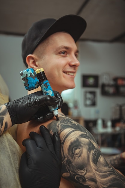 Bel homme se faire tatouer au studio d'art alternatif