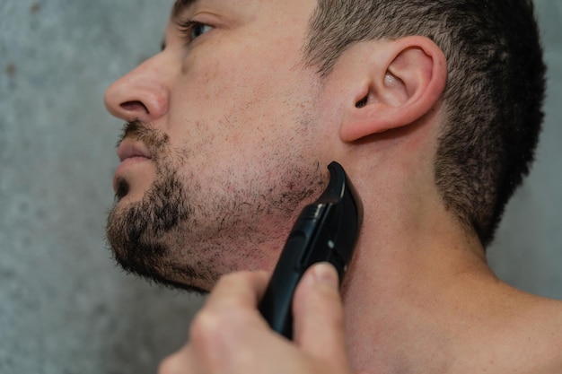 Bel homme se rasant la barbe au rasoir électrique Hygiène du matin