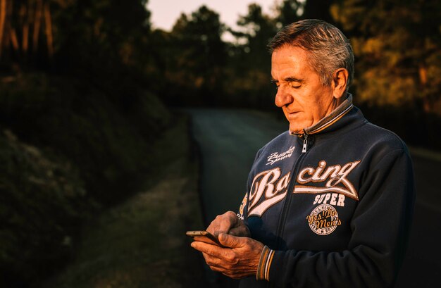 Bel homme senior à l&#39;aide de smartphone