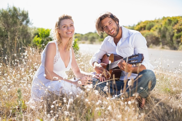 Bel homme sérénade sa copine avec guitare