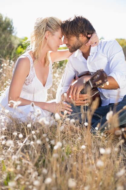 Bel homme sérénade sa copine avec guitare