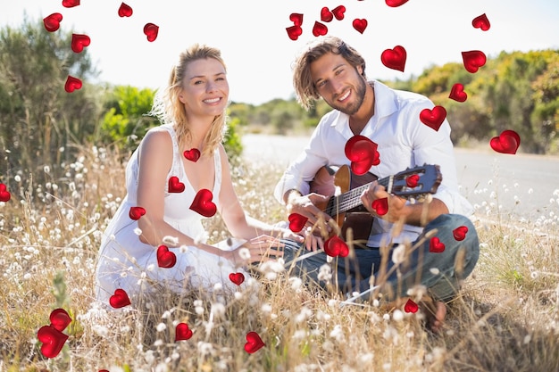 Bel homme sérénade sa petite amie avec guitare contre la conception du coeur de la Saint-Valentin