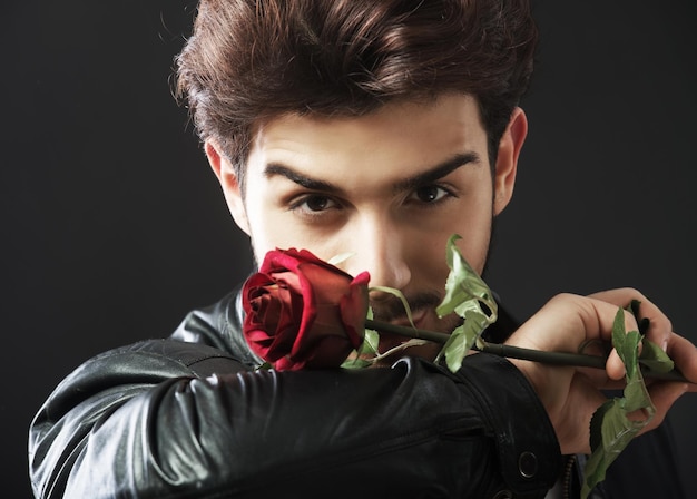 Bel homme avec une seule rose rouge