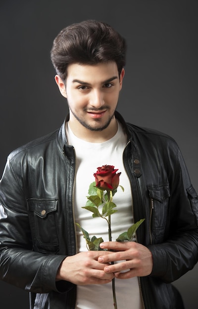 Bel homme avec une seule rose rouge